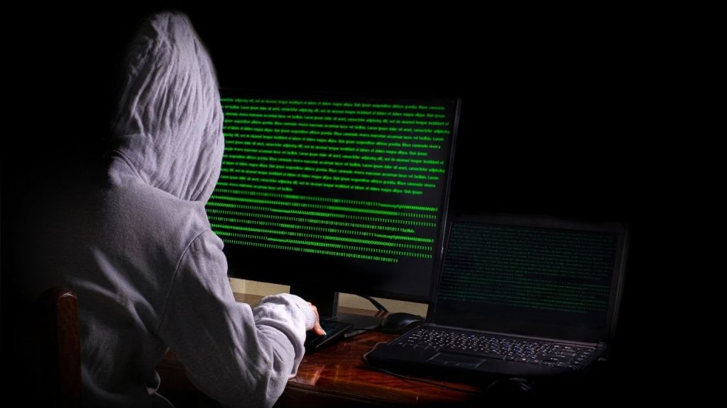 Person coding in darkness symbolizing unethical AI development and artist exploitation.